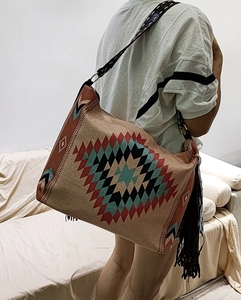 Detail of bohemian woven shoulder bag featuring geometric diamond patterns and brown tassels