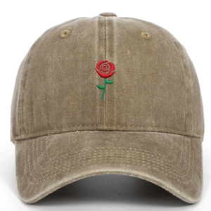 Close-up of red rose embroidery on a vintage washed khaki cotton baseball cap