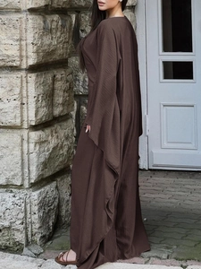 Détail de la texture d'une robe longue marron foncé avec tissu plissé et manches longues