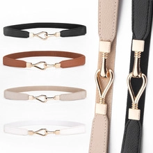 Detail of four colorful elastic belts with interlocking gold metal buckles on white background