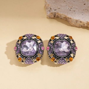 Vintage geometric square purple crystal earrings with orange accents on stone display