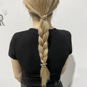 Detailed back view of gold metal hair clips with pearl accent styling on a ponytail braid