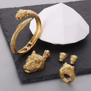 Macro detail of golden tiger head jewelry set including bracelet, ring and pendant