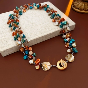 Detailed macro shot of multi-strand beaded necklace with shell beads and golden clasp