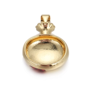 Détail macro du pendentif pépin de grenade doré avec sommet couronne et métal dépoli