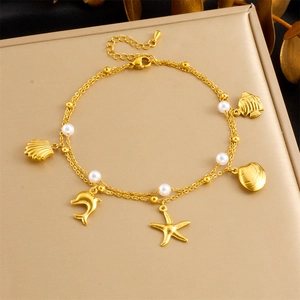 Detail of double-layer gold anklet with starfish and shell pendants on a display stand