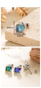 Macro view of titanium steel snake claw earring featuring iridescent opal gemstone ball
