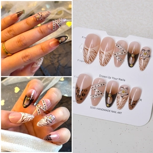 Detailed view of handmade press-on nails with leopard print, 3D flowers and gold chain