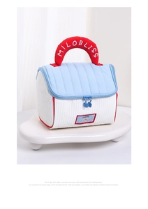 Dettagli della texture trapuntata della borsa blu e bianca con manico rosso