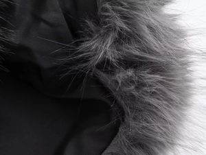 Close-up of luxury black jacket fabric with premium grey faux fur collar detail