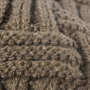 Macro detail of warm jacquard knitted beanie showing thick texture and stitch patterns