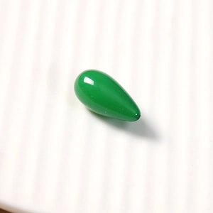 Macro shot of a smooth green teardrop-shaped resin charm for DIY jewelry making and crafts