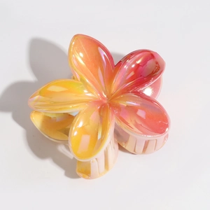 Macro detail of laser gradient orange frangipani hair claw clip with pearlescent finish
