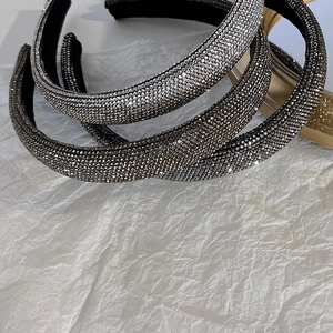 Primo piano di cerchietti imbottiti con strass densi in colori argento e oro champagne