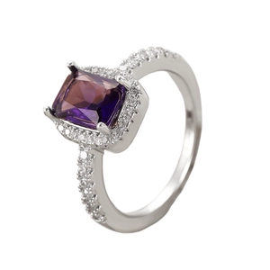 Macro detail of silver ring with square purple gemstone and shimmering pave stones