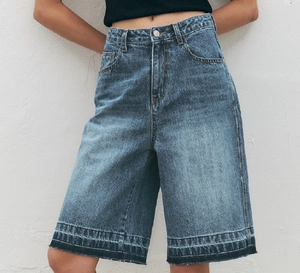 Close-up of high-waisted blue denim shorts with washed texture and clean hem finish