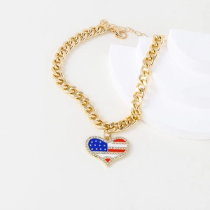 Detail of gold curb chain pet necklace with American flag heart pendant and rhinestones