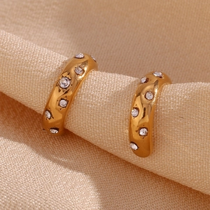 Macro shot of 18K gold plated C-shaped ear cuffs with sparkling inlaid white rhinestones