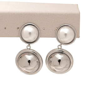 Detailed view of modern two-tone drop earrings featuring white and silver metal spheres