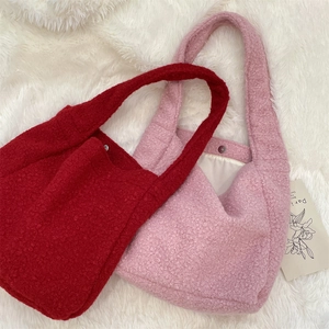 Detail view of burgundy and pink boucle tote bags with soft texture and metal buckle