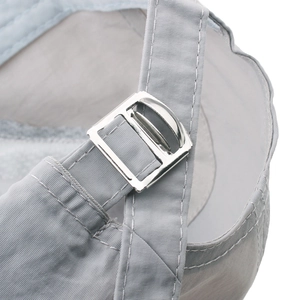Close-up of adjustable metal buckle and quick-dry fabric on grey sports baseball cap