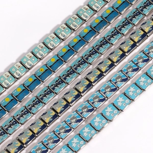 Macro shot of 9mm stainless steel Italian charm links with ocean-themed enamel patterns