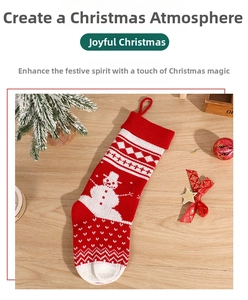 Detail of red and white knitted Christmas stocking with snowman pattern on wooden surface