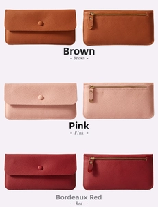 Dettaglio di portafogli a busta in pelle gialla, rosa e rossa con tasche a zip