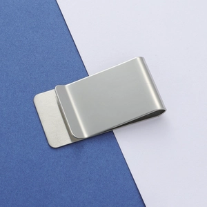 Close-up of a silver brushed stainless steel money clip on a blue and white background
