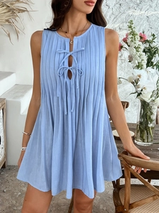 Detail view of light blue sleeveless pleated dress with front tie and cut-out design