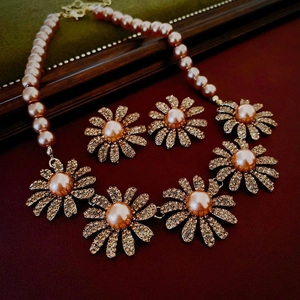 Macro view of vintage daisy pearl necklace set with champagne rhinestones and pink finish
