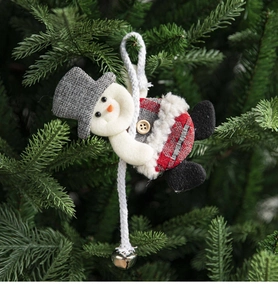 Detail of plush snowman Christmas tree ornament with red plaid fabric and silver bell
