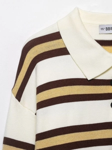 Detailed macro view of the knitted polo collar with a black button and striped texture
