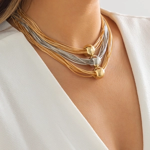 Close-up of multilayer punk chain necklace with gold and silver metallic ball pendants