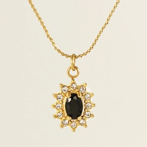 Macro shot of an 18K gold-plated double chain necklace with a black oval zircon pendant
