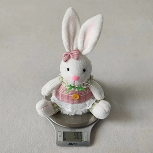 Close-up of lightweight Easter bunny plush weighing 96.5g on a digital kitchen scale