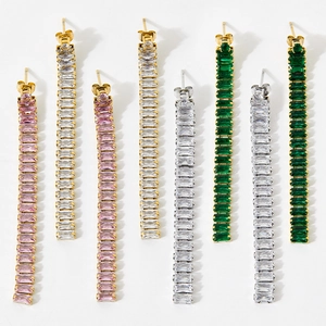 Macro view of long linear tassel earrings with colorful zircon stones in gold and silver