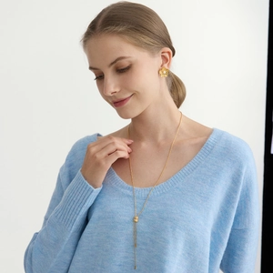Gros plan de boucles d'oreilles fleurs en perles et collier en Y sur modèle femme