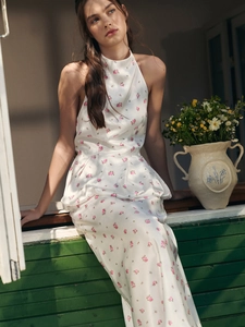 Detail of floral satin halter dress with smooth texture and delicate pink flower print