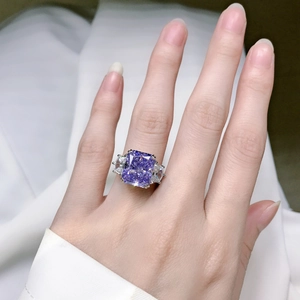 Close-up of a violet cushion cut carbon diamond ring on finger with silver band