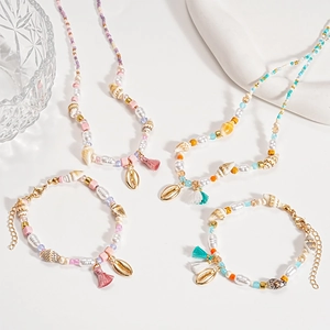 Bohemian beach jewelry set with pearls, shells and tassels on white background