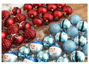 Détail macro de boules de Noël peintes en rouge et bleu avec motifs de Père Noël