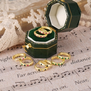 Close-up of classic S925 silver hoop earrings with colorful zircon stones on vintage score