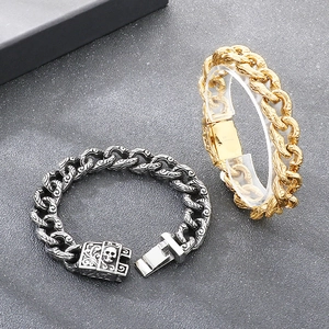 Detailed view of silver and gold Cuban chains with skull clasps and vine engravings