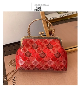 Detail of red floral embroidery on vintage chain handbag with gold metal clasp