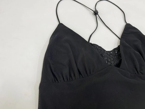 Detail view of the black mesh dress showing delicate lace trim and pleated texture