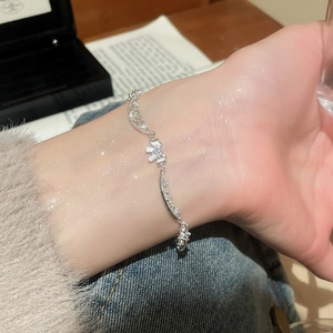 Macro detail of silver layered lace bracelet with zircon heart and wavy design