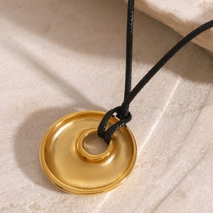 Minimalist gold hollow circular pendant on black cord necklace with metallic finish