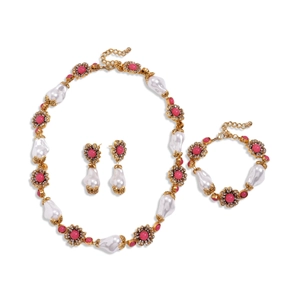 Vintage floral jewelry set with pink stones and pearls on a white background