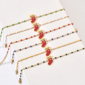 Détail de bracelets de Noël avec breloques chaussettes rouges et fermoirs mousquetons